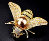 Frumoasa brosa de albina aurie cu o perla