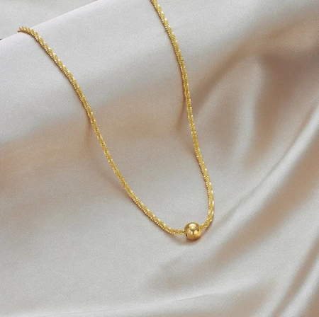 Colier delicat de aur cu o bilă de oțel chirurgical